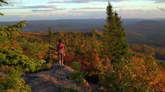 Autumn Fall Foliage Colorful Forest with Woman Walking on Travel Hike Looking at Stunning View. Hiking woman on mountain forest summit n Mont Tremblant, Laurentians, Quebec, Canada