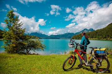 Obraz premium Cycling, rear view of a biker in green Idyllic Landscape scenery. Rural landscape of Bavaria Lake Walchensee. European Alps in Germany, Europe Bavarian Prealps