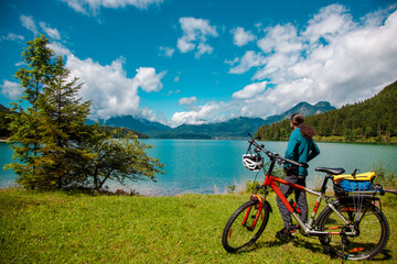 Cycling, rear view of a biker in green Idyllic Landscape scenery. Rural landscape of Bavaria Lake Walchensee. European Alps in Germany, Europe Bavarian Prealps
