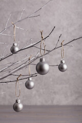 Merry Christmas! Christmas concept, minimalism. Branches of trees with Christmas tree decorations on a gray background of a silver color.