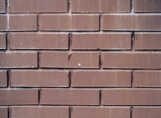 Weathered texture of painted old dark brown and red brick wall background. Brickwork.