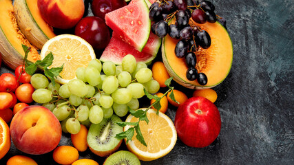 Assorted fresh fruits on dark background.