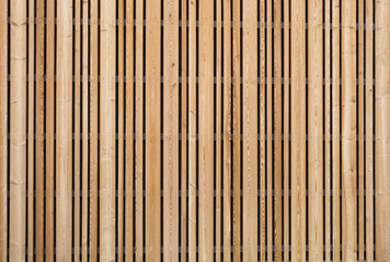 Background modern facade or ceiling made of larch wood strips in the outdoor
