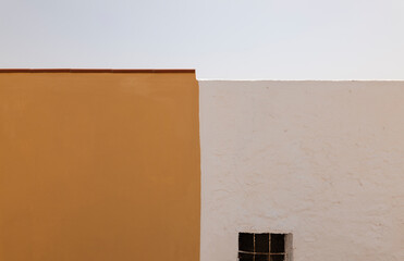 Yellow and white wall against clear sky