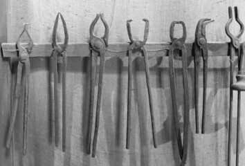 old blacksmith utensils hanging on a wall