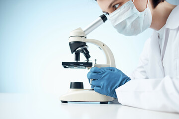 woman in laboratory looking through microscope close-up biotechnology science