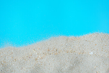 Sea beach sand texture on blue background with copy space. Summer background concept. 