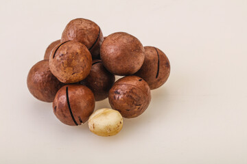 Brown macadamia nut heap over background