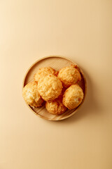 Toasted coconut cake in plate, on beige pastel background. Top view, flatlay. Nobody. Soft lighting