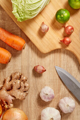 Prepare ingredients for healthy and nutritious meals.  Carrot, cabbage, dry onion, red pumpkin, ginger on brighten wooden background. Top view. Clean and Fresh Food. Healthy vegetables.