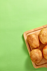 Potato with pastel concept. It's on brighten green background. Top view. Clean and Fresh Food.