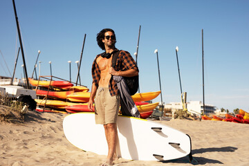 Handsome man with surfboard. Young handsome man preparing for the surf.