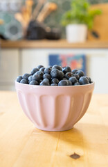 bowl of fresh blueberries on rustic kitchen table