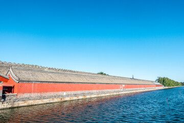 The city walls and moat of China's Forbidden City under a blue sky