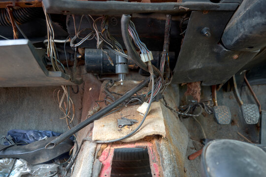 Disassembled vehicle for transportation and transport.horizontal image of the inside of the front of a very old broken down car,Dirty brake,clutch,and accelerator gear shifter pedal of manual