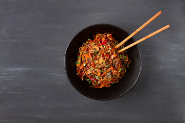 Udon noodles with mushrooms and vegetables, in sauce, with sesame seeds, Asian vegetarian food,...