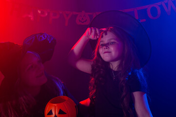 Fototapeta premium Funny child girl and woman in witches costumes for Halloween with pumpkin Jack.