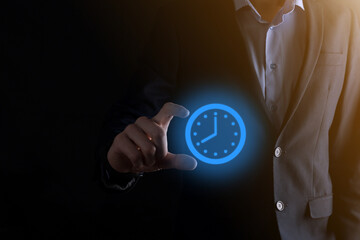 Businessman hand holds the icon of hours clock with arrow. Rapid execution of the work.Business time management and business time is money concepts