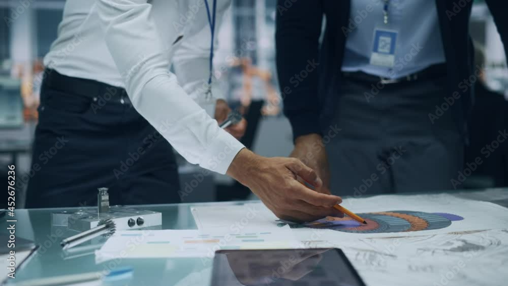 Poster Close Up of Two Automotive Engineers Working in Office at Car Factory. Industrial Designer Shows Conceptual Electric Engine Parts to Colleague, Discussing Work in Technological Laboratory.