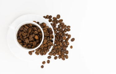 Grains of coffee in a cup on a white background. View from above. Copy space.