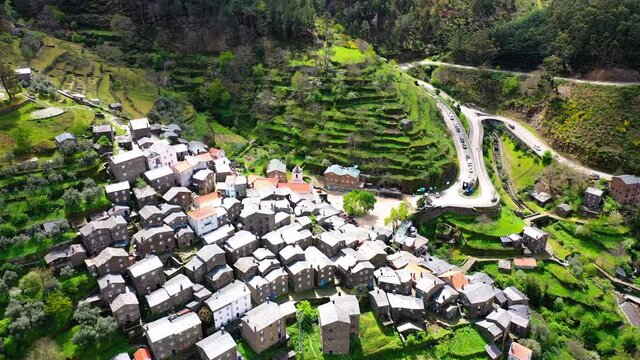 Aerial Forward Tilt Up Scenic View Of Houses Over Hills During Sunny Day - Piodao, Portugal