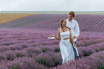 A couple in love in a lavender field in white clothes