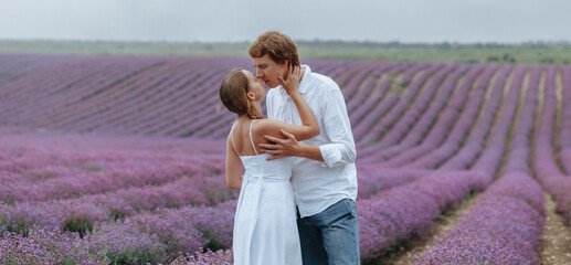 A couple in love in a lavender field in white clothes