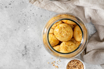 Homemade Norwegian butter cookies with almonds in a glass jar on a light gray culinary background. Traditional Scandinavian pastries top view