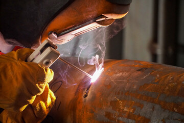 A professional welder welds a pipe with a diameter of DN250 for a process pipeline and corrects...