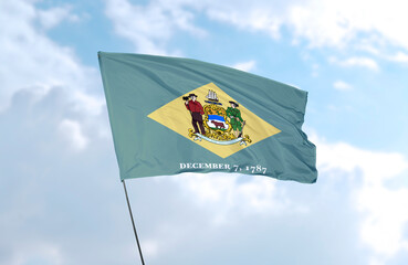 Flag of Delaware in front of blue sky, realistic 3D rendering