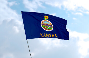 Flag of Kansas in front of blue sky, realistic 3D rendering