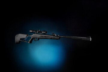 Black pneumatic rifle with an optical sight. Black modern air rifle with a telescopic sight on a...