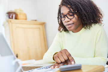 Business woman in the home office calculates with the calculator