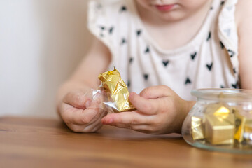 Two-year-old girl has some chocolates. Should children be allowed to eat sweets? The effects of...