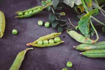 Raw green peas on dark stone background