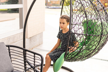 Little girl sitting in a chair suspended cocoon
