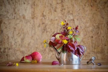 Obraz na płótnie Canvas autumn bouquet in iron teapot on wooden table