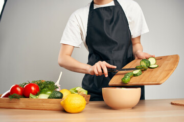 chef in black apron slicing vegetables housework cooking