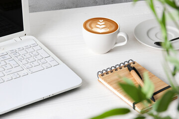 Cup of hot barista coffee on office table. Milky coffee at work