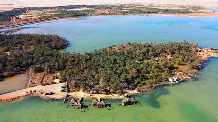 Aerial Panning Scenic View Of Green Landscape Amidst Lake On Sunny Day - Al Madam, UAE