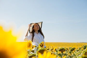 woman in a hat in a field of sunflowers