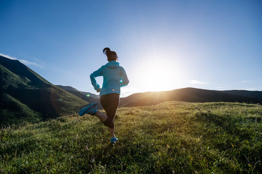 Young woman runner running at mountain top