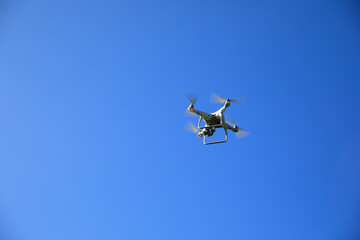 White drone with camera flying in the air