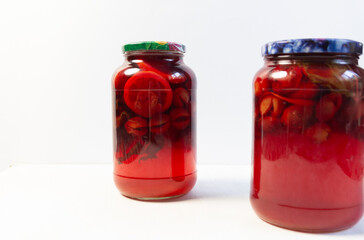 compote made of plums, lemon, mint in glass jar on white background