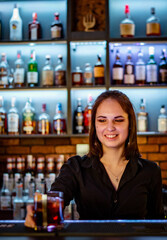 Portrait of young attractive woman bartender Making Cocktail in bar