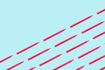 Obraz premium Creative pattern made of red felt-tip pen on a light blue background with copy space. School concept.Flat lay.