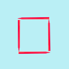 Creative frame made of red felt-tip pen. School concept. Pastel blue background with copy space.