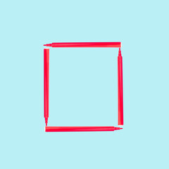 Creative frame made of red felt-tip pen. School concept. Pastel blue background with copy space.