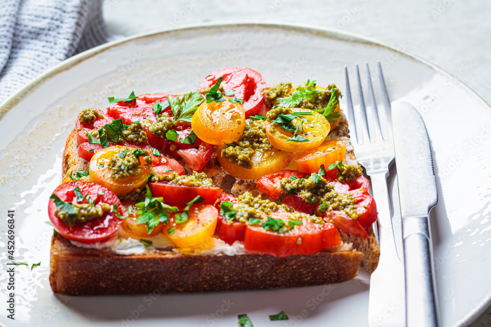 Wall mural Toast with tomatoes, pesto and curd cheese. Italian cuisine concept.