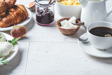 Breakfast table with cornflakes, croissants and cup of coffee. Gray tile background, copy space.
